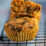 carrot oat muffins cooling on a wire rack, with a golden-brown, crumbly top and visible oats and chocolate chips