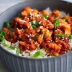 Sweet & Spicy Glazed Tofu on a bed of rice in a gray bowl