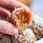 close up of a a hand holding carrot-cake-bliss-balls