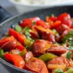 Sausage Veggie Stir Fry in a pan with rice in the background