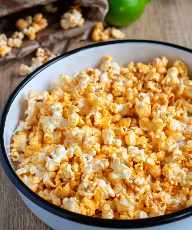 Chili Lime Popcorn in a big white bowl with scattered popcorn in the background