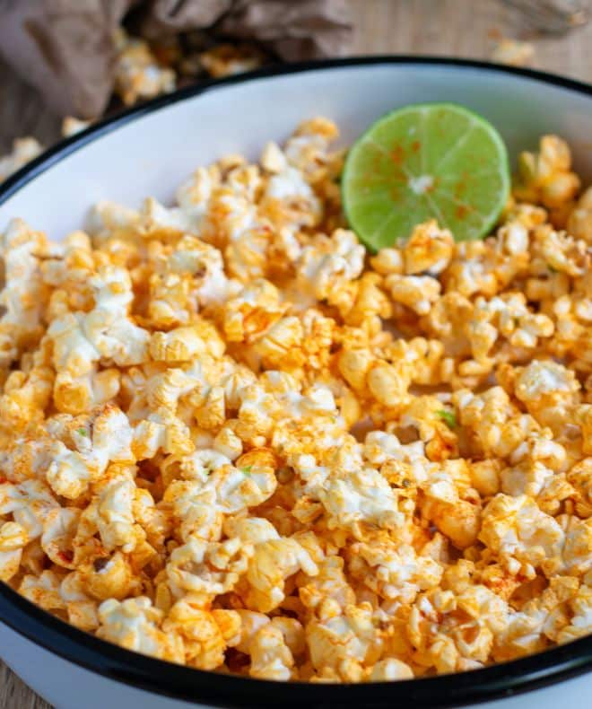 Chili Lime Popcorn in a big white bowl with a lime in side