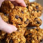 A hand holding a Chewy Pumpkin Chocolate Chip Cookie