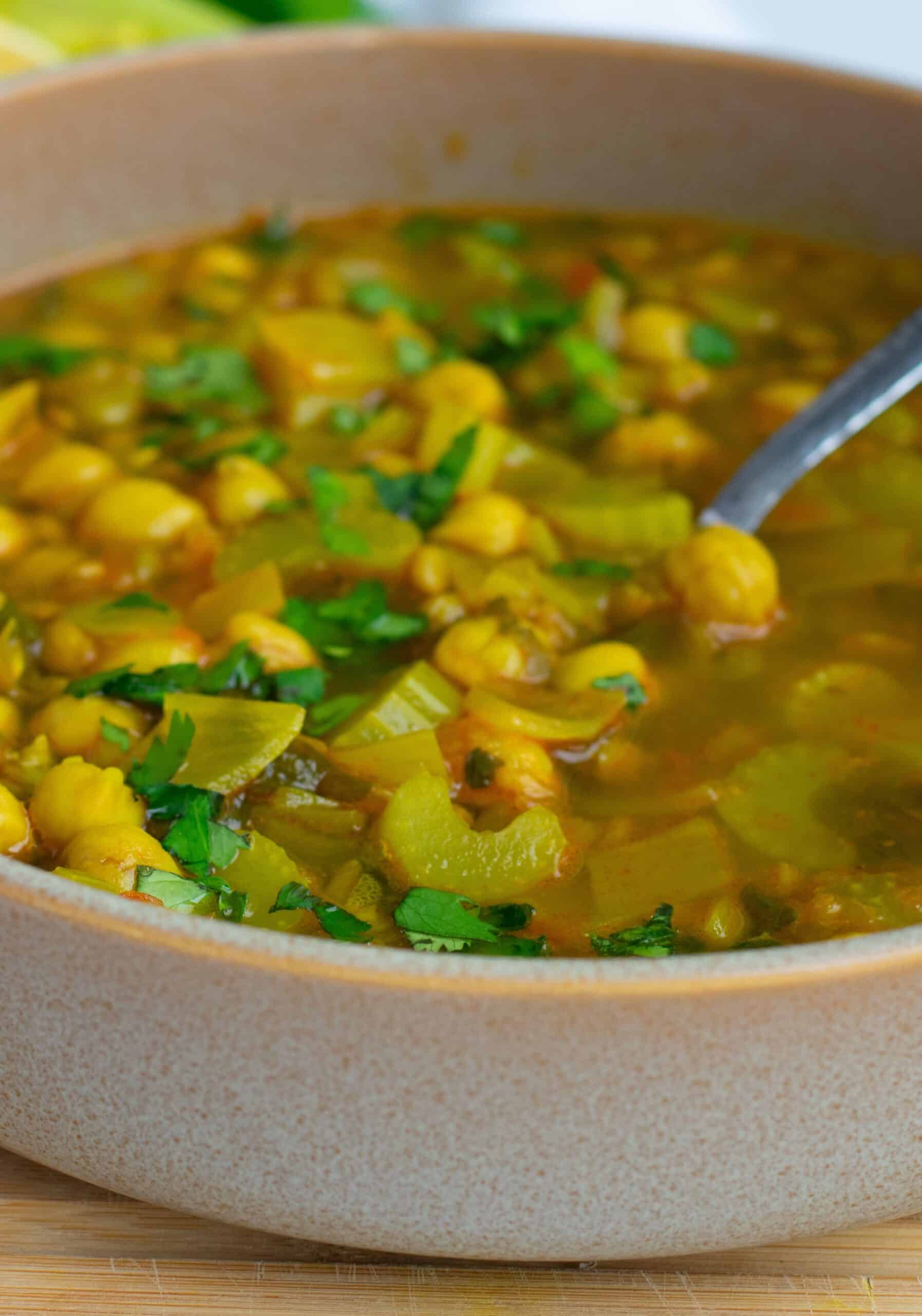 Bowl of Moroccan harira soup with lentils, chickpeas, and a lemon wedge
